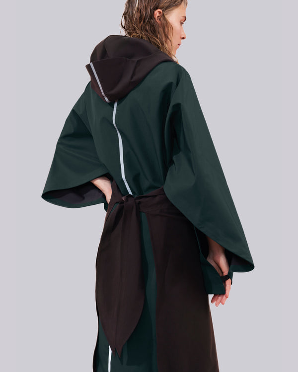 this open cape is a combination of black and green with a hood and a reflective stripe down the back.