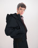 Person wearing a black, waterproof, bomber jacket on a white background