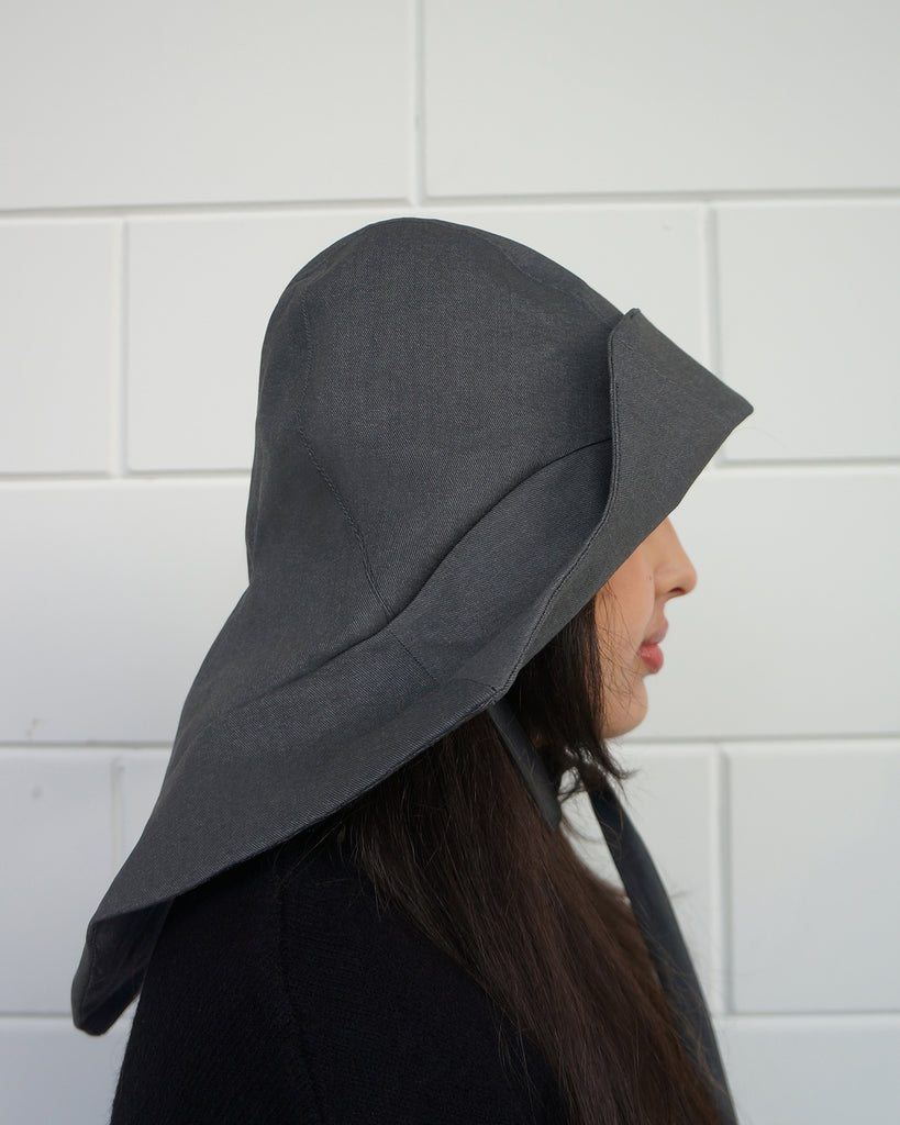 side view Person wearing a denim, waterproof rain hat