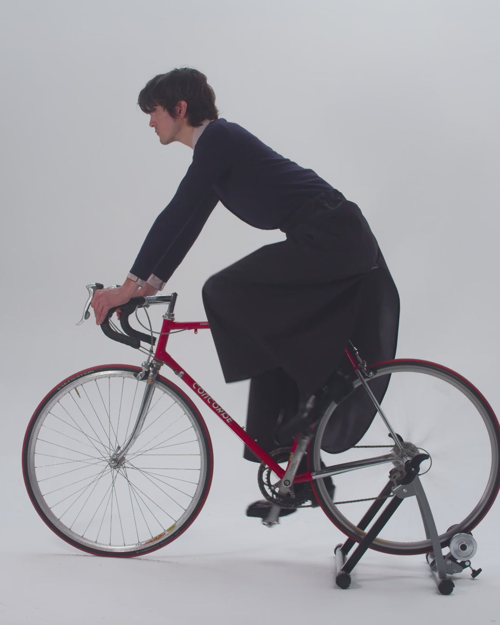 man on a race bike wearing rainproof skirt that transforma into rain trousers/pants
