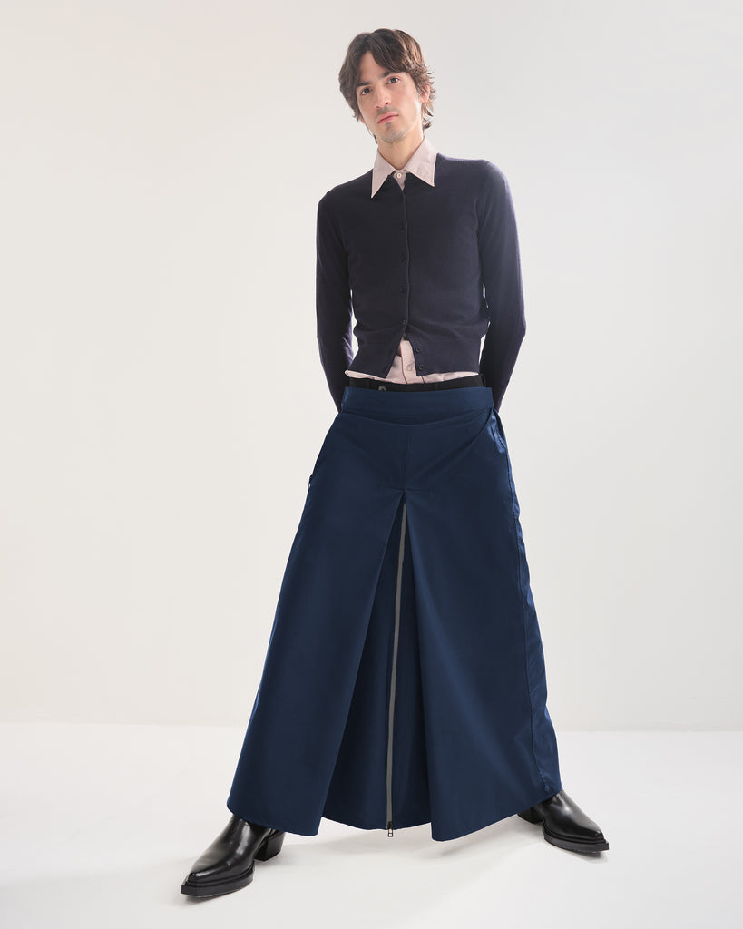 Person wearing a navy blue outfit with a long rain skirt on a white background